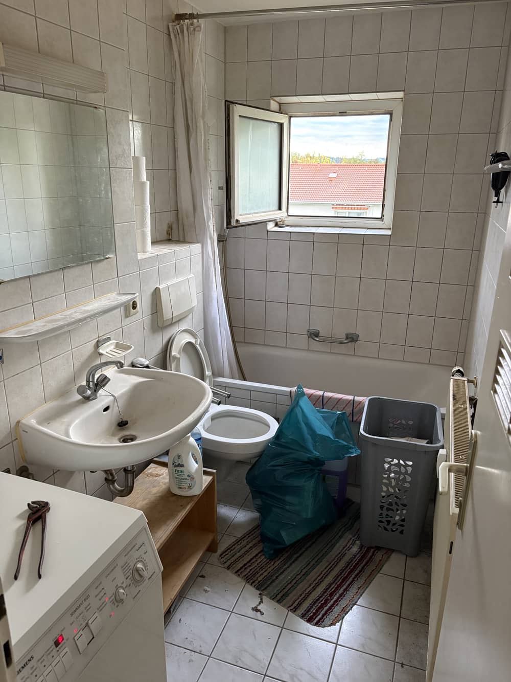Badezimmer vor der Räumung mit Wäschekorb und Utensilien