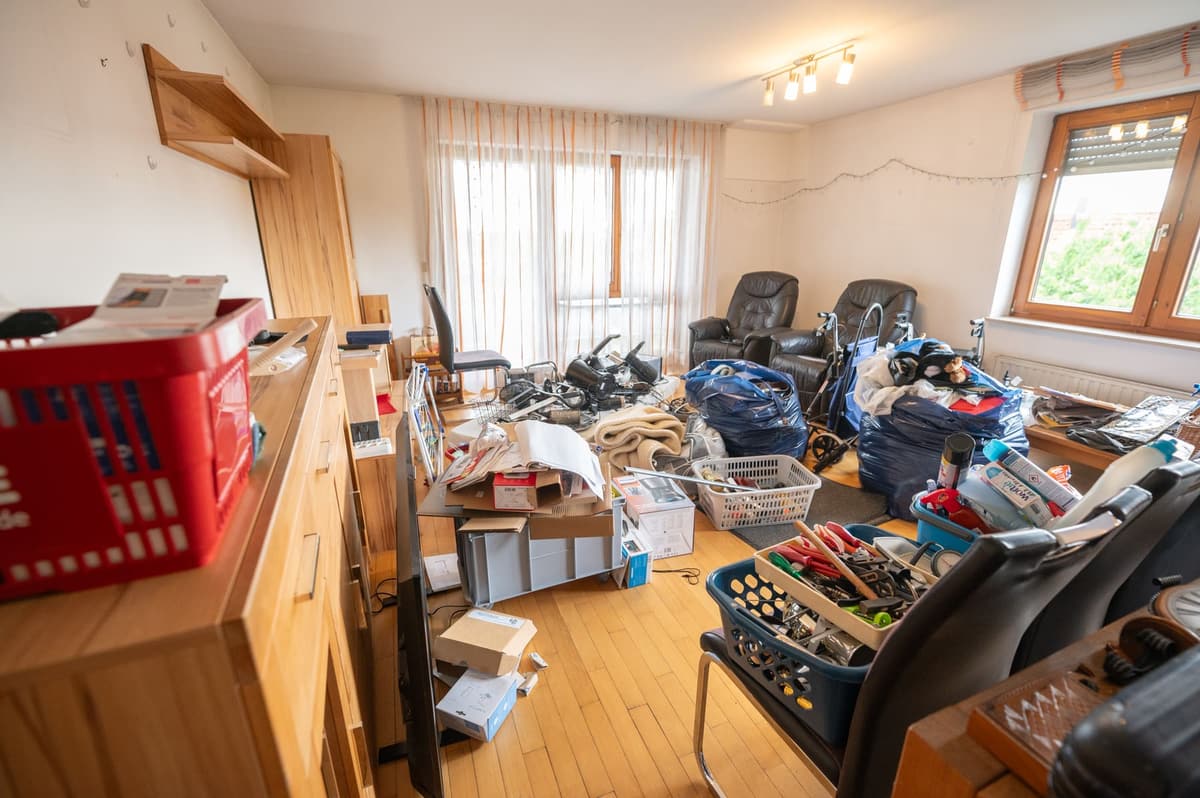 Wohnzimmer vor der Auflösung, vollgestellt mit Möbeln, Säcken und Pflegehilfsmitteln